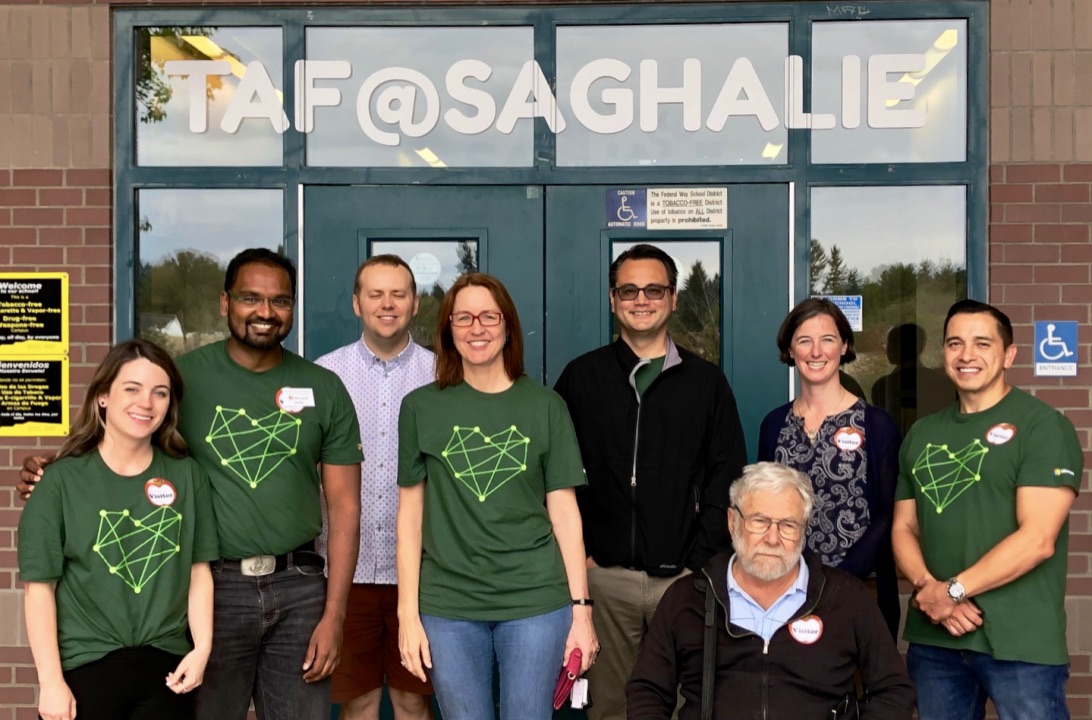 Group of volunteers from Microsoft pose in front of the school.