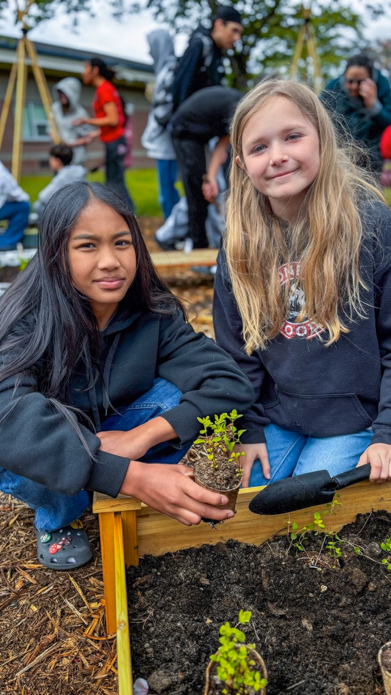 Students pose next to their successful plant starts